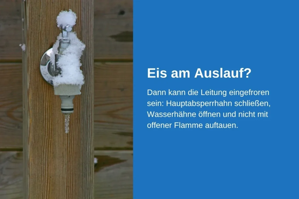 Verschneiter Außenwasserhahn an einer Holzwand mit Schlauchanschluss, an dem ein Eiszapfen hängt